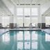 Indoor pool at Residence Inn by Marriott Providence Lincoln in Lincoln with tall windows and lounge chairs