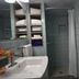 Lariat Motel in Hardin bathroom with sink, shower, tiled walls, and shelving