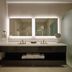 Pickering Casino Resort bathroom vanity with double sinks, lit mirrors, and glass shower in Pickering