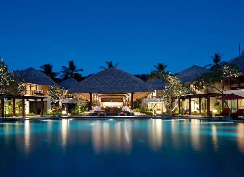 Sudamala Resort, Senggigi, Lombok poolside view at dusk with tropical cabanas and palm trees