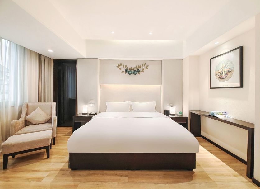 Pairui Hotel Chengdu guest room with king bed, lounge chair, and bright minimalist decor