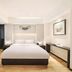 Pairui Hotel Chengdu guest room with king bed, lounge chair, and bright minimalist decor