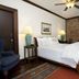 Park Plaza Hotel in Winter Park guest room with four-poster bed, brick accent wall, ceiling fan and patterned rugs