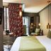 Hôtel Aoriste & Spa Paris guest room with king bed, patterned curtain, and seating area