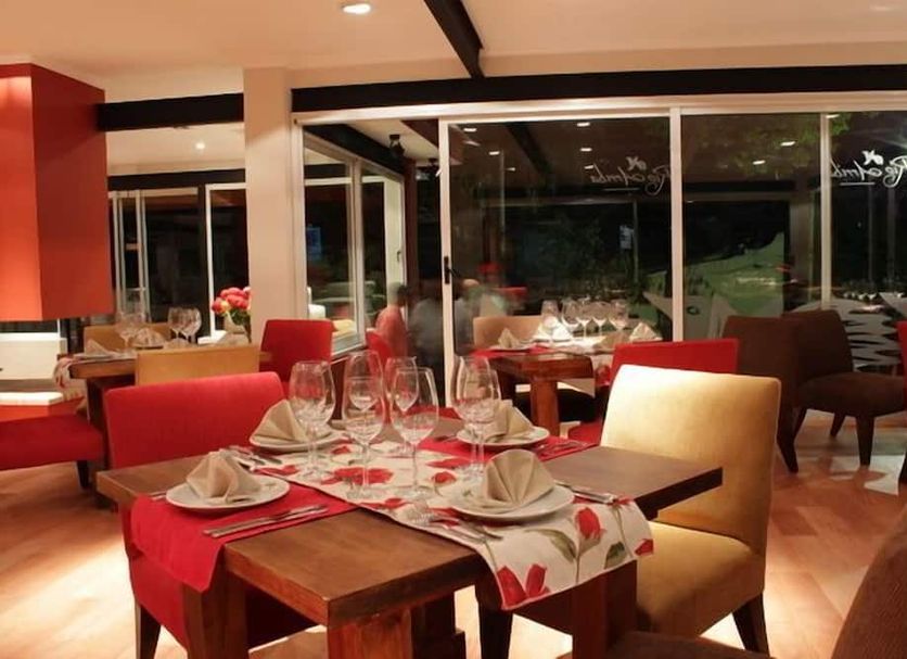Rio Arriba Suites Apartments y Resto in Bella Vista dining room with red chairs and set tables