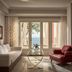 The Danai, Nikiti: elegant suite with sea view through glass doors and red armchair