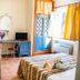 Resort Itaca - Nausicaa room in Rossano with bed, desk, sofa, open balcony door and window