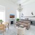 Carmelita Valletta lounge with dining table, sofa, fireplace, and kitchen in bright white interior
