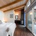 Backeddy Resort And Marina room with wood ceiling, bed, and sliding glass doors to a balcony in Egmont
