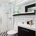 Bauergården Gränna bathroom with black-and-white tile, glass shower, and white vanity