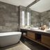 Adiwana Resort Jembawan Ubud bathroom with freestanding tub, double vanity, and stone tile walls