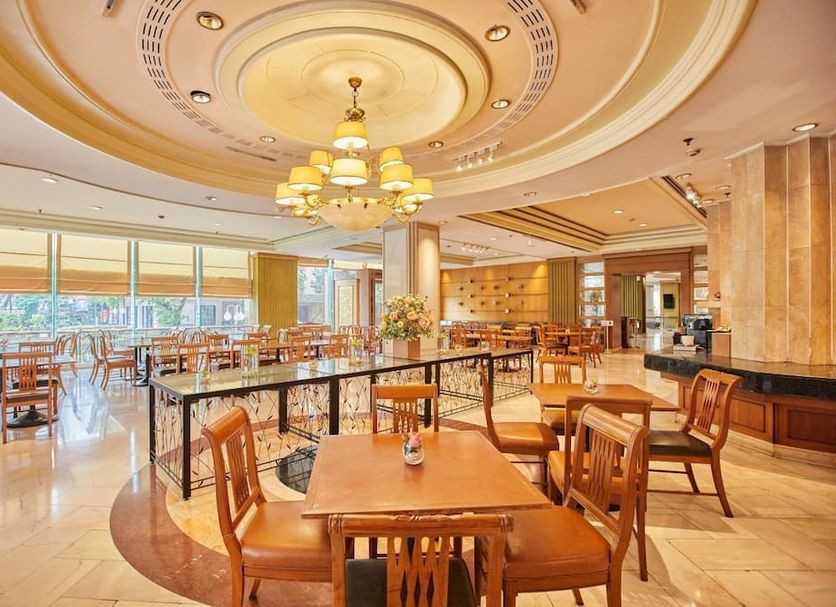 The Royal City Hotel in Bangkok dining room with chandeliers and set tables