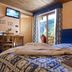 Miramonti Valtournenche room with twin beds, balcony door, mountain-view painting, and TV