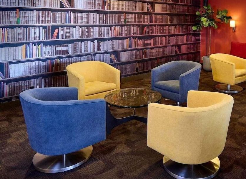 Livinn Hotel Cincinnati/Sharonville Convention Center lounge with colorful swivel chairs and bookcase wall in Sharonville