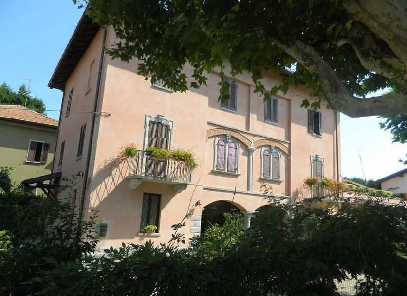 Albergo Michieletto in Montano Lucino, peach-colored hotel facade with arched windows and flower boxes