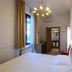 Soggiorno Burchi in Florence guest room with double bed, window, chandelier, and open bathroom door