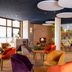 Hôtel Mercure Trouville-sur-Mer lounge with colorful chairs, fireplace and large windows in Trouville-sur-Mer