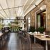 Covered outdoor dining terrace at Fh55 Grand Hotel Mediterraneo in Florence with wicker chairs and river views