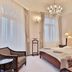 Sun Palace Wellness Hotel in Mariánské Lázně guest room with chandelier, twin bed and armchair