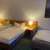 Hotel Westfalia in Halle guest room with three single beds and bedside lamps