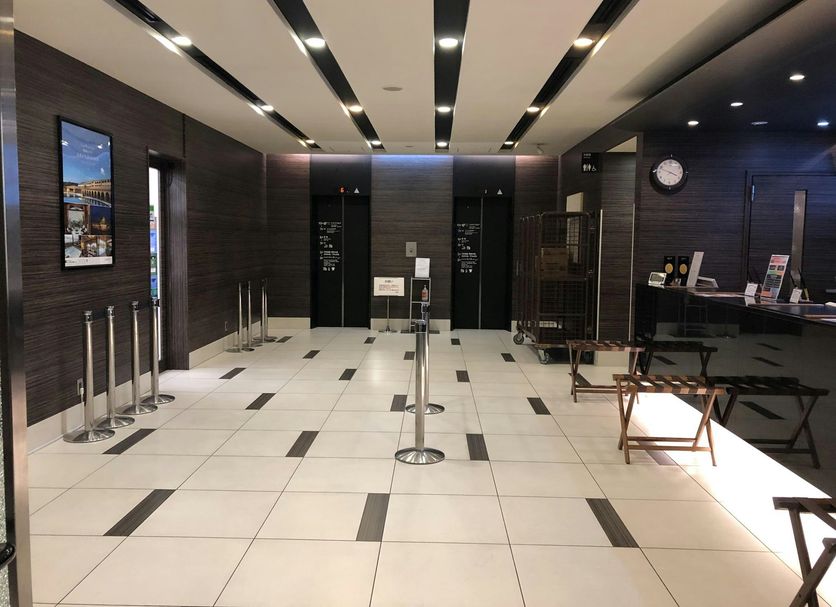 Dormy Inn Hakata Gion lobby in Fukuoka with tiled floor, elevator banks and front desk seating