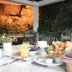 Contact Hotel Le Moulin Neuf Chantonnay breakfast table with pastries, orange juice and a garden backdrop