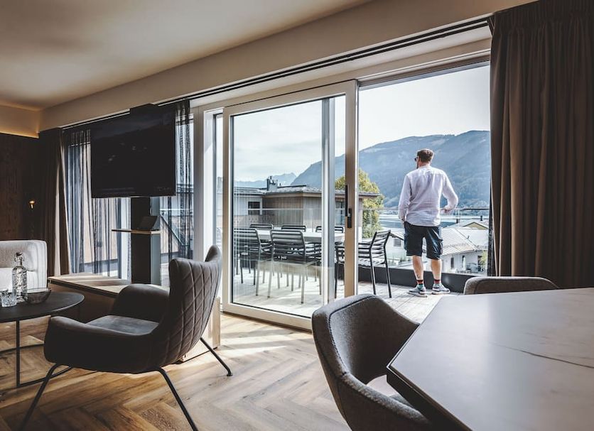 The Gast House Zell am See room with balcony doors, lake and mountain view, and outdoor seating.