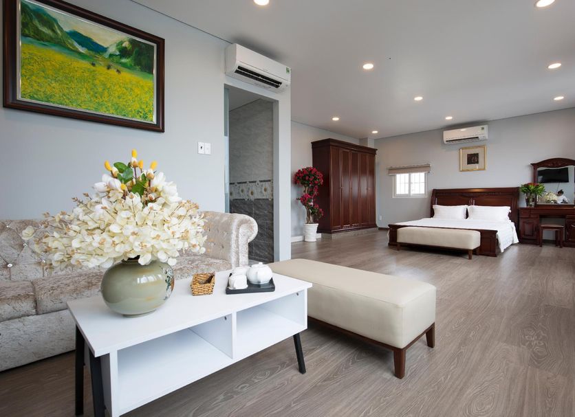 Sophia Hotel in Ho Chi Minh City guest room with king bed, sofa, coffee table and air conditioning