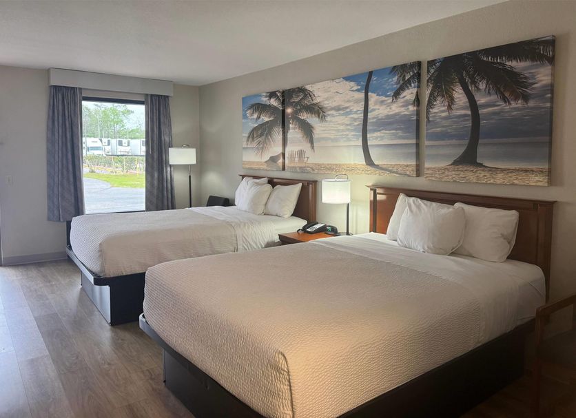 Days Inn by Wyndham Lake City I-10 guest room with two double beds and beach wall art in Lake City
