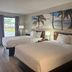 Days Inn by Wyndham Lake City I-10 guest room with two double beds and beach wall art in Lake City