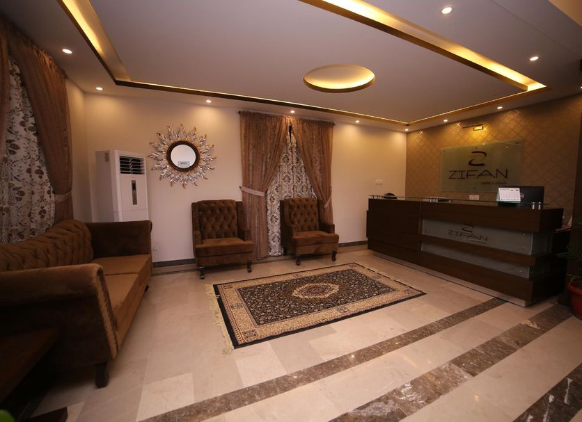 Zifan Hotel & Suites lobby in Karachi with front desk, seating area and patterned rug