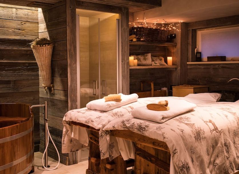 Auberge de La Maison in Courmayeur, cozy spa room with wooden tub, shower, and massage table