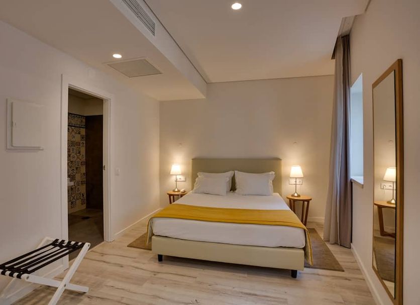 Hotel Riverside Alfama in Lisbon: bright guest room with double bed, bedside lamps, and full-length mirror