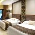 The Arnawa Hotel in Pangandaran with twin beds and a balcony view of the pool and trees