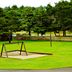 The Polynesian Resort in Ocean Shores with a playground beside a grassy area and pine trees
