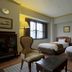 Hotel Monterey Nagasaki in Nagasaki: twin beds, armchair, table, and window in a guest room