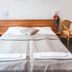 Hotel u České Koruny in Hradec Králové: double bed with fresh linens, bedside tables and chair