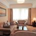 Qilu International Hotel Harbin guest room with sofa seating, coffee table, and window light