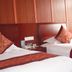 Yiwu Mango Hotel in Jinhua: twin beds with red accents and wood-paneled wall