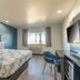Studio 6 Suites Perris hotel room with king bed, desk, wall-mounted TV and window
