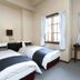 Hakuba Gondola Hotel room in Hakuba with two single beds, window, and desk with TV