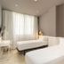 Paral·lel Barcelona hotel room with two twin beds, desk, and large window with curtains