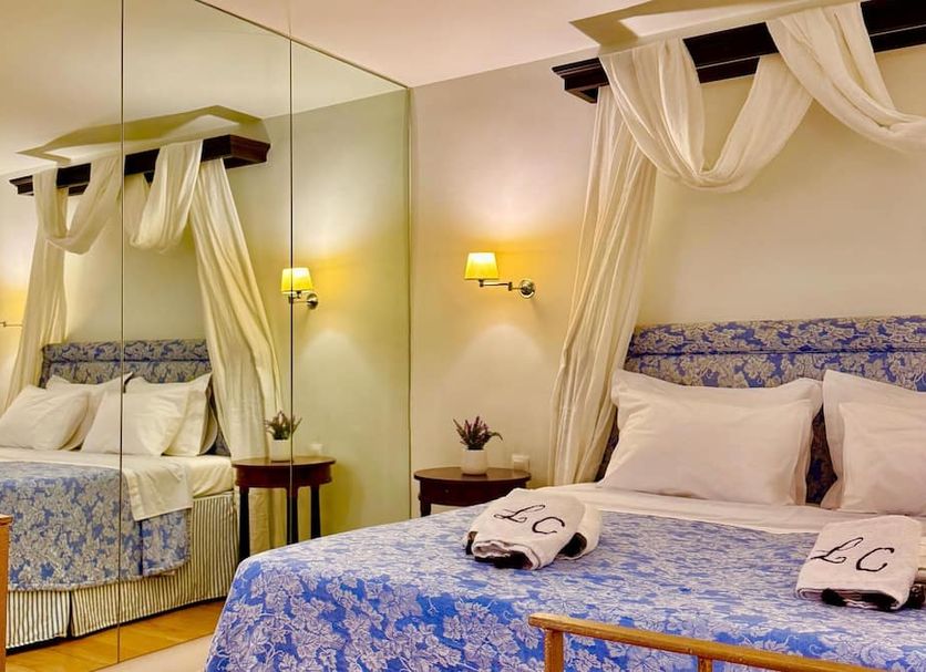 Great Greece Le Convivial Suites in Xylókastro: canopy bed with blue floral bedding and mirrored wall