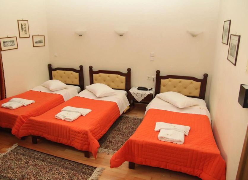 Hotel Panellinion in Tríkala: triple room with three single beds and orange bedspreads
