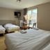 Hôtel La Métairie in Cordes-sur-Ciel guest room with three beds and a small table by the window