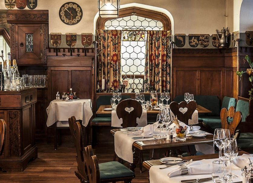 Romantik Hotel Wilden Mann Luzern dining room with wooden paneling and set tables in Lucerne