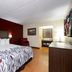 Red Roof Inn Kenly - I-95 guest room with king bed, desk, chair and bathroom doorway