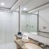 Slaviero Vitória bathroom with glass shower, granite vanity, mirror and folded towels