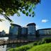 Wuxi Idea Garden Hotel in Wuxi with modern glass towers beside a lake under a blue sky