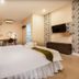 The Loom Rangsit in Pathum Thani: guest room with bed, desk, TV, and patterned accent wall